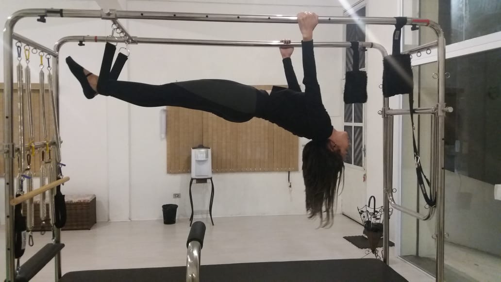 Aluna praticando pilates no aparelho