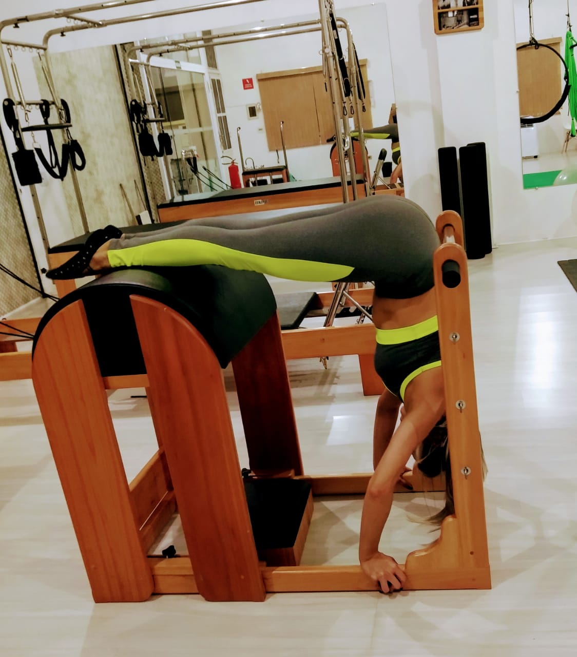 Aluna praticando pilates no aparelho