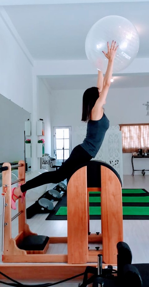 Aluna praticando pilates no aparelho